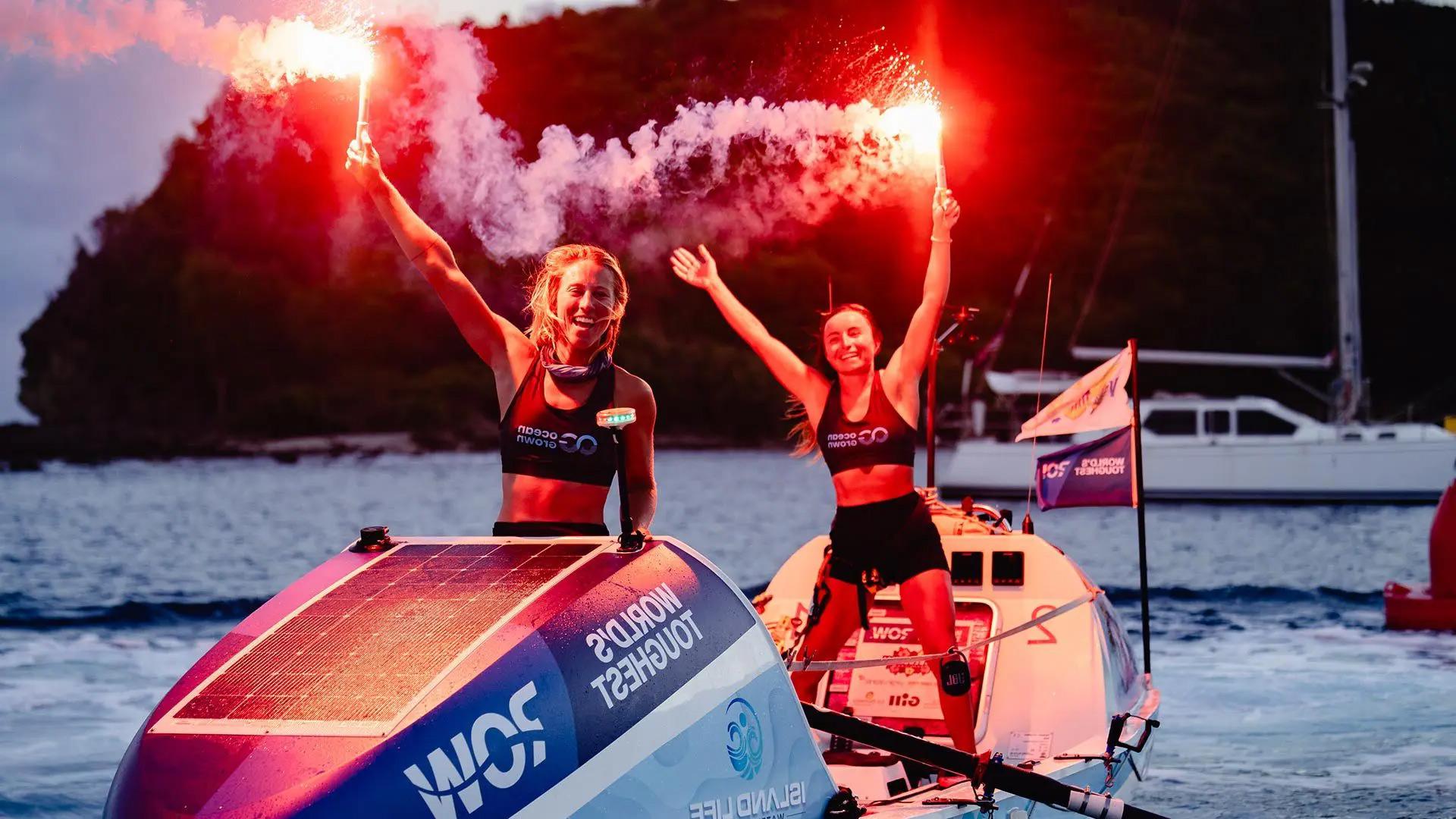 Lisa Roland, left, and Nini Champion ’16 raise celebratory flares at the finish line of the World’s Toughest Row in Antigua last month. The pair, known as Team Ocean Grown, finished the 3,000-mile race in 45 days, one hour and 27 minutes, setting a world record for a female duo.